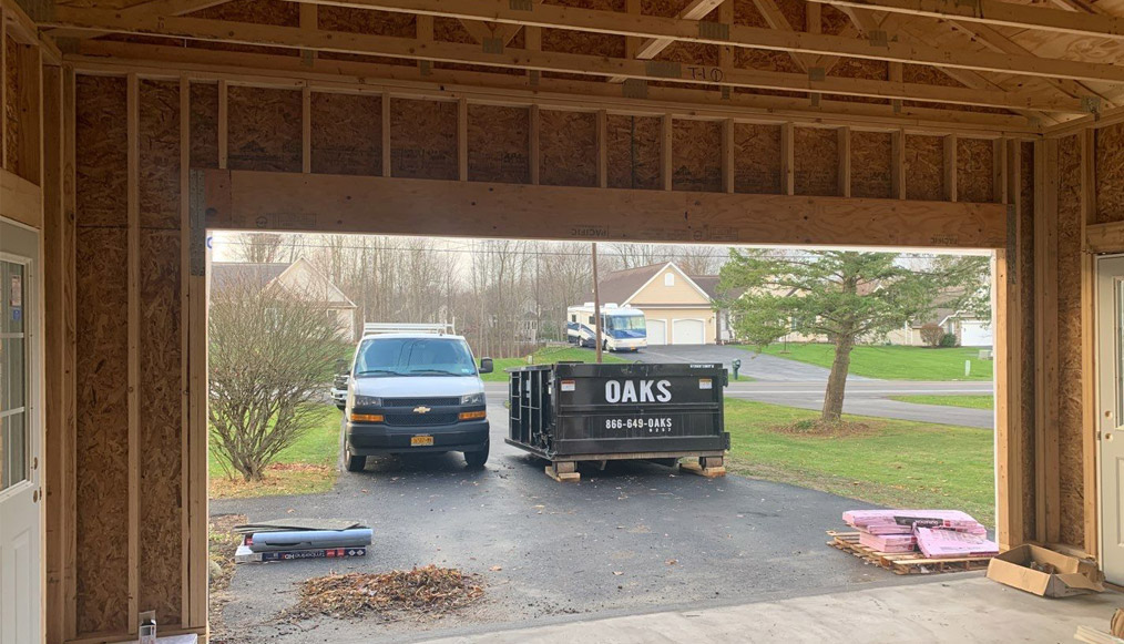 View from the garage of a dumpster in a driveway
