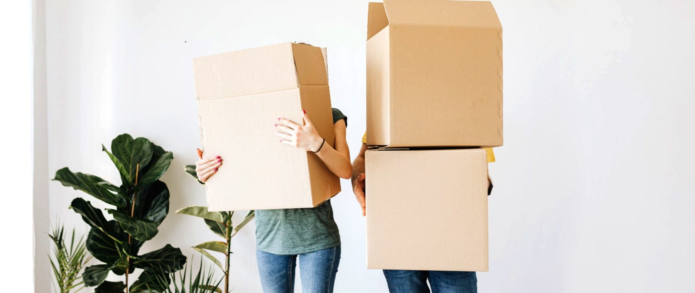 Couple holding moving boxes