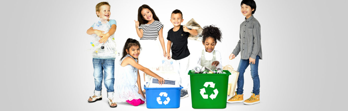 Smiling kids with recycling bins