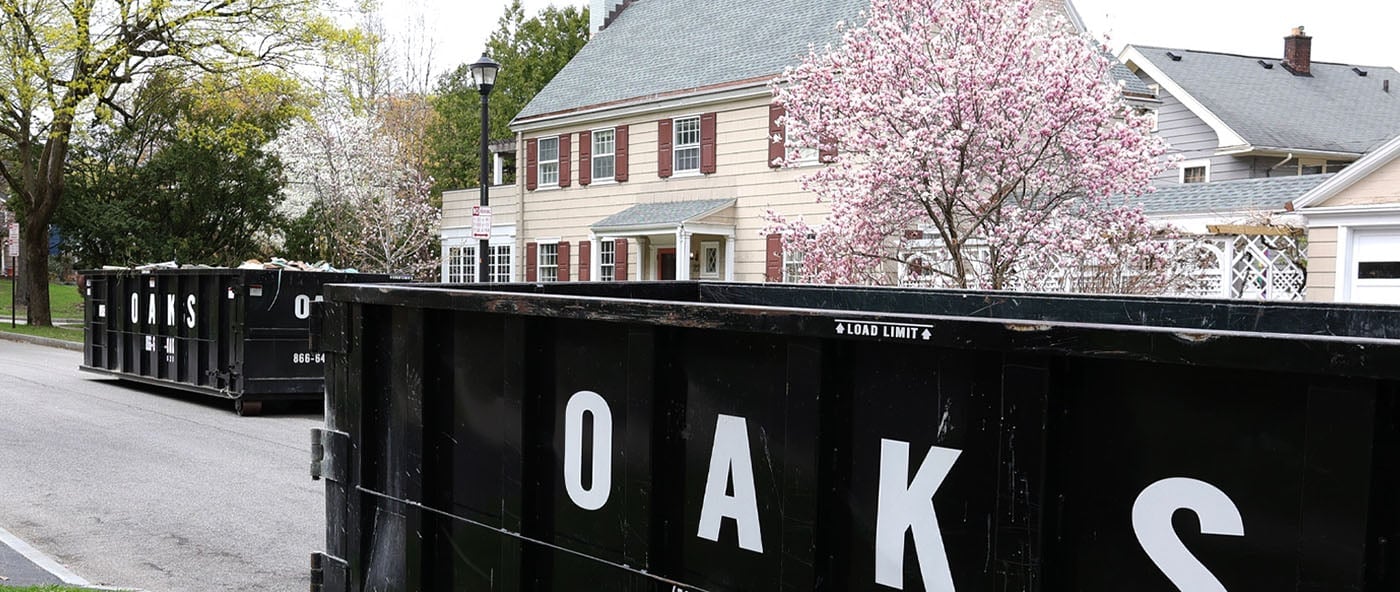 A black dumpster on a residential street