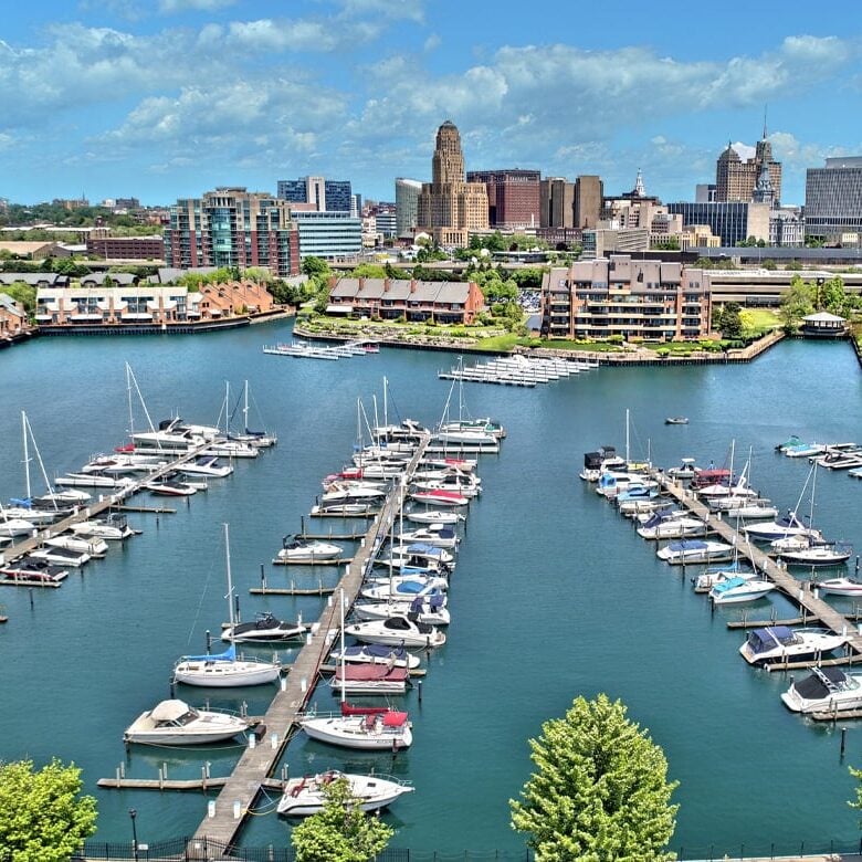 Marina with boats docked in front of city skyline A marina with boats docked in front of a city skyline